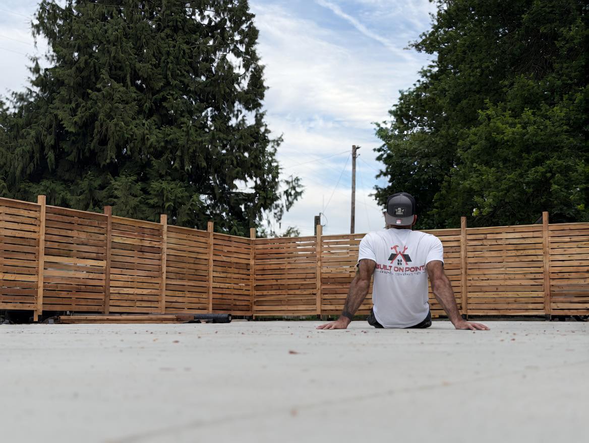 Newly built wooden deck with sitting area and privacy fence by Built On Point LLC